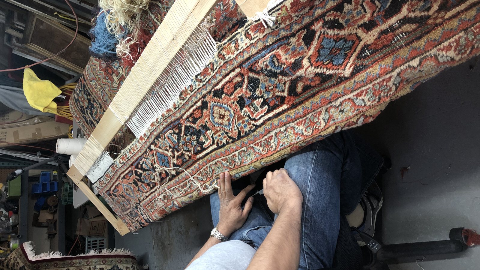 Fringe being re-knotted on a loom frame